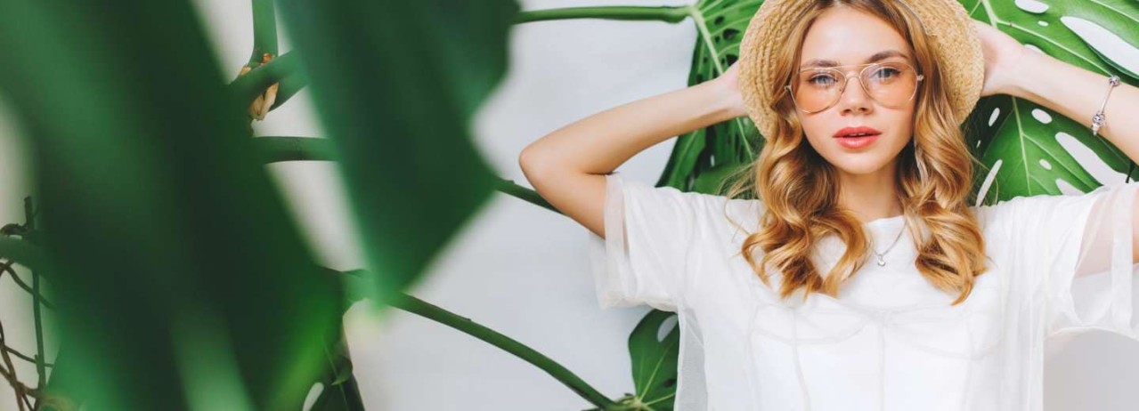 Girl wearing fashionable clothing surrounded by plants