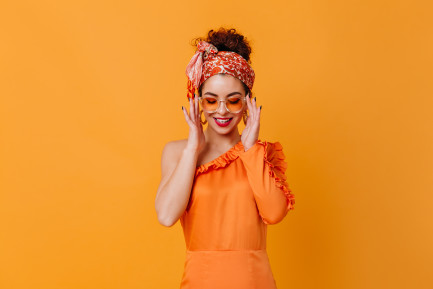 Girl wearing orange silk on an orange background