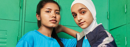 Two people in front of green lockers